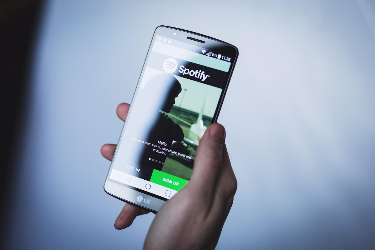 na foto aparece uma pessoa escutando o spotify no celular