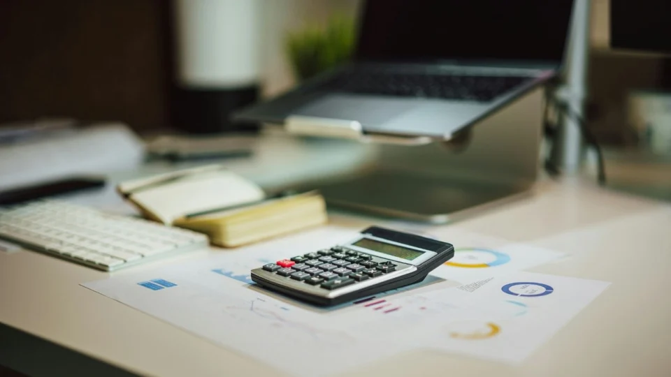 Calculadora e papéis para calcular novas taxas da Reforma Tributária.